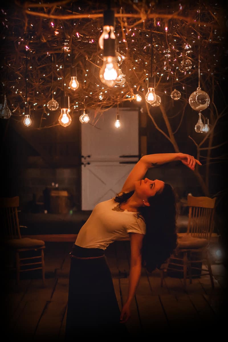 woman dancing under lightbulbs